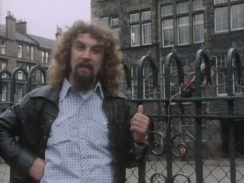 Billy Connolly standing outside St Peter's Boys School - where he attended the Stewartville Street school before heading to St Gerard's in Govan.