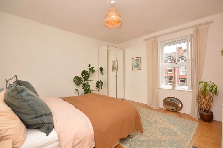 The spacious master bedroom with lots of space for furniture and windows overlooking the front garden.