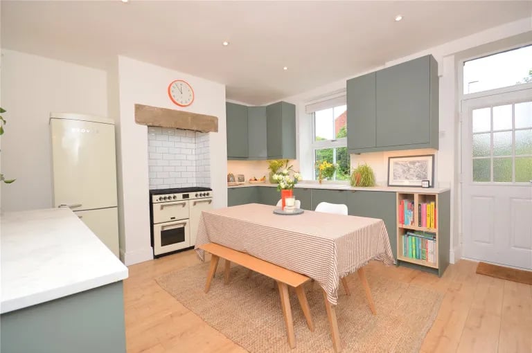 The spacious dining kitchen with stylish slab front wall and base units and quartz effect work tops.