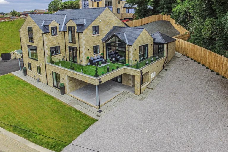 The stunning six bedroom property with its green balcony and large driveway.