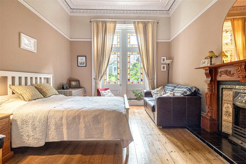 Bedroom one with beautiful, glazed doors to the rear, with shutters, wooden flooring and ornate ceiling cornice.