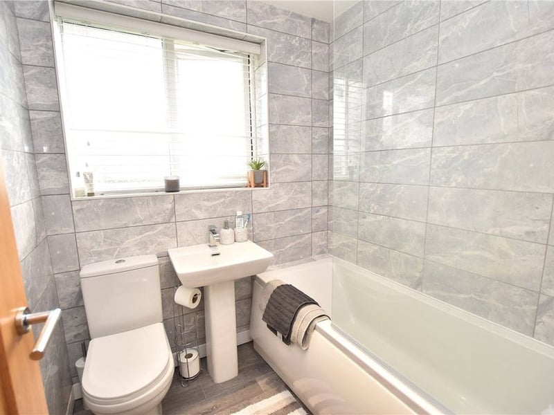 The thee-piece family bathroom with shower and screen over the bathtub.