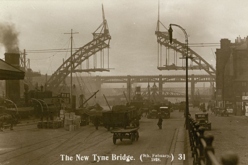 A view along Newcastle Quayside showing the Tyne Bridge under construction, 9 February 1928 (Tyne & Wear Archives & Museums)