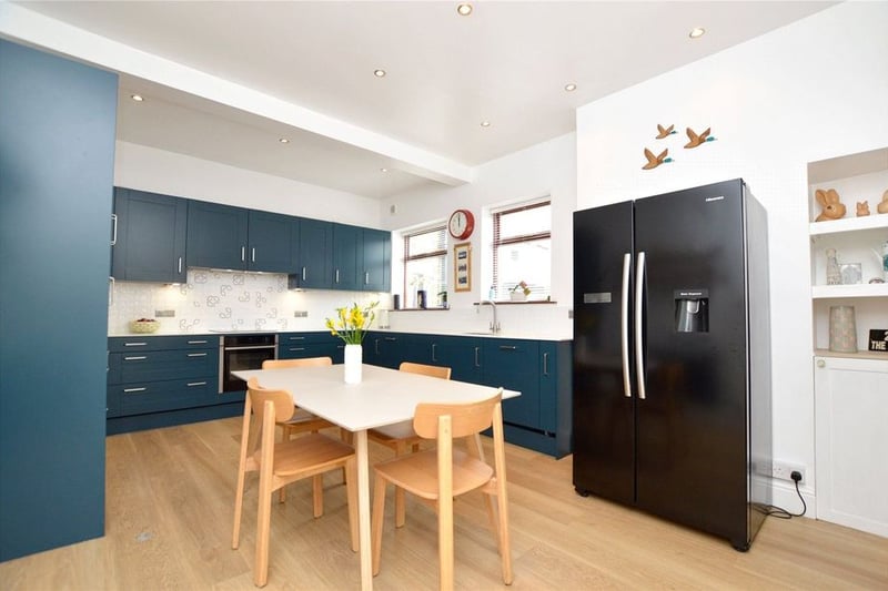 The open plan dining kitchen is recently updated to incorporate a range of navy shaker-style fitted units.