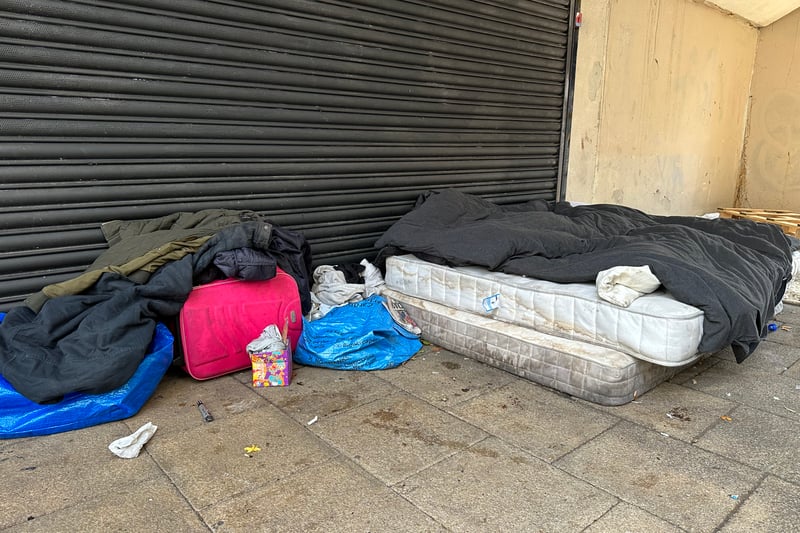 Mattress, clothing and bedding sit at the lower level of the shopping area - evidence of rough sleeping at the location