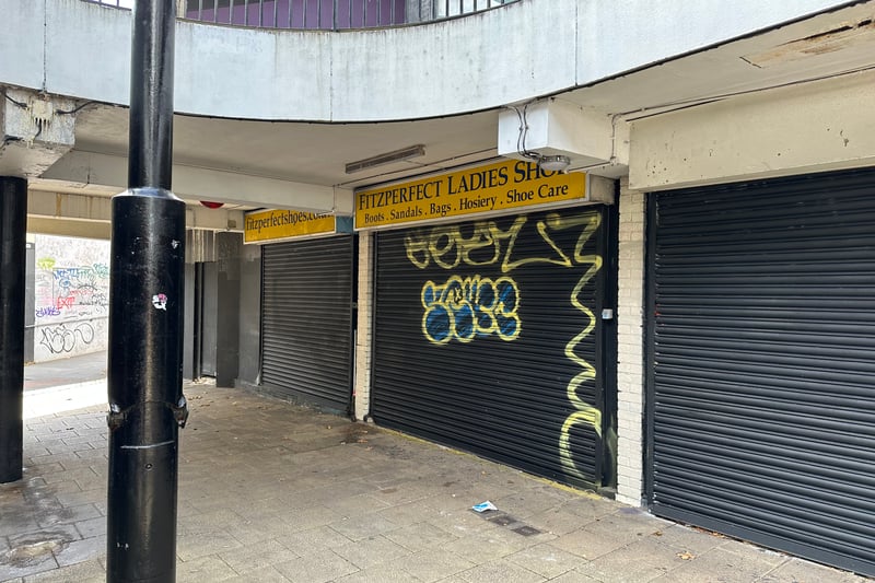 Graffiti covers the shutters of the former Fitzperfect Ladies Shop at the lower level entrance to Haymarket Walk