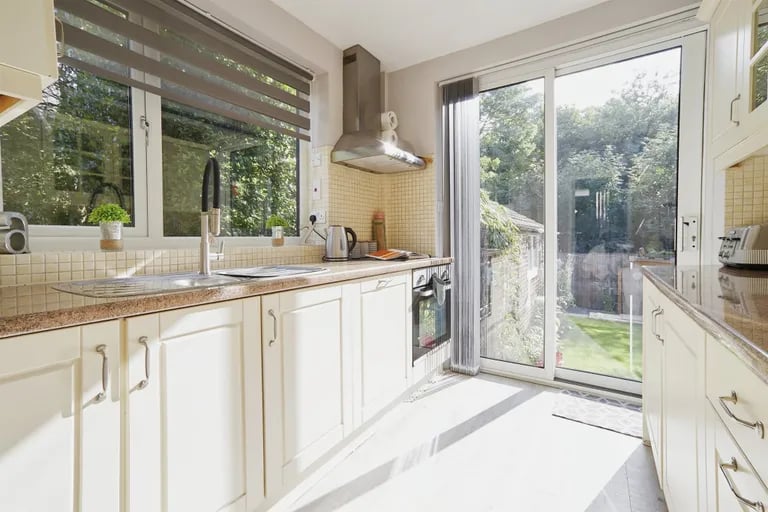 The modern fitted buttermilk shaker style kitchen with sliding doors to the rear garden.