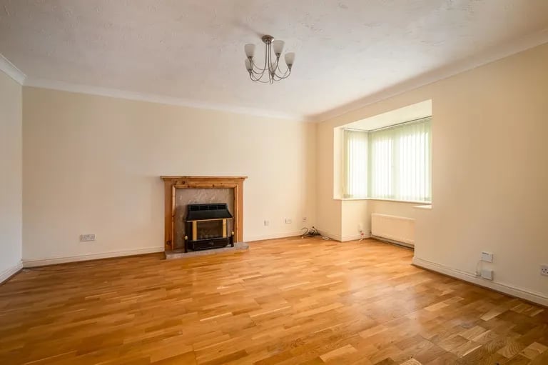 The spacious living room has a fireplace and a bay window.