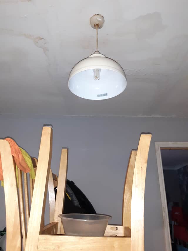 Water and waste from the leaks in the bathroom are coming through the light fitting downstairs, with a bowl on the dining table catching the dripping.