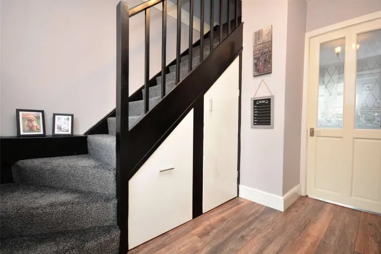 The bright hall with stairs to first floor and under-stairs storage.