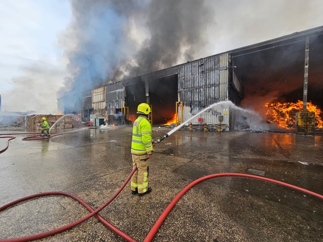 A number of firefighters remain at the scene. The fire can be seen the be stretching along the inside of the Biffa waste  recycling centre. Photo: SYFR