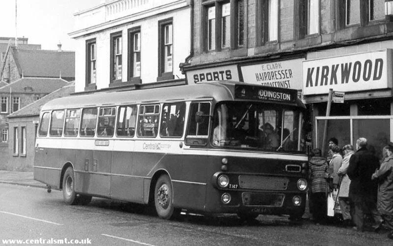 A bus to Uddingston from Hamilton Road - back in the day before the buses were privatised and when you could get a packet of drum alongside a short, back, and sides - as seen in the Hairdresser / Tobacconist behind the bus.
