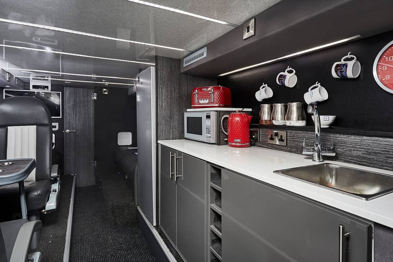 The ground floor of the double decker tour bus, featuring small kitchenette area and small dining area (Credit: MM Band Services)