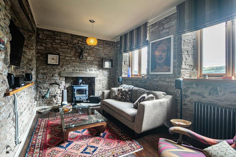 The snug, tucked away on the ground floor, has a cottage feel with stone walls and warm lighting.