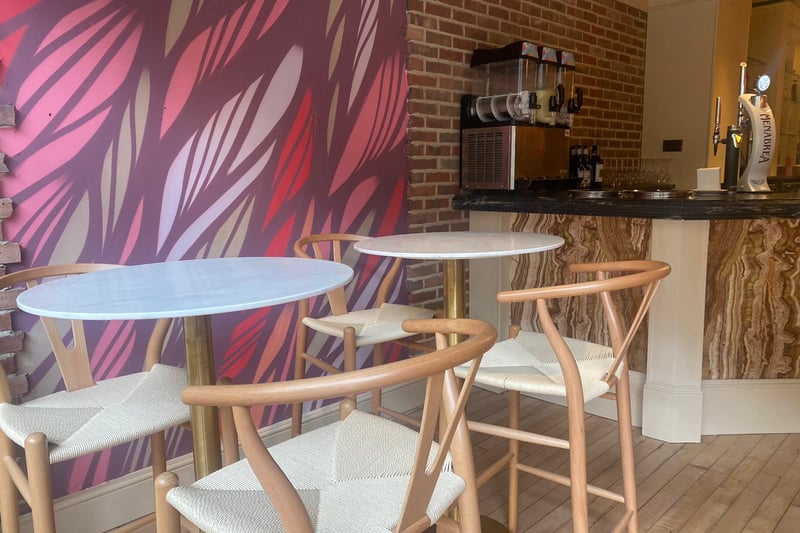 Cafe Mercy’s high stool and table area has comfortable, rattan seating.