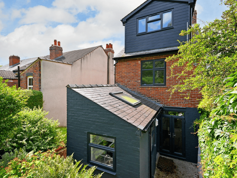 The quirky extended kitchen and black tiling makes for a unique-looking exterior.