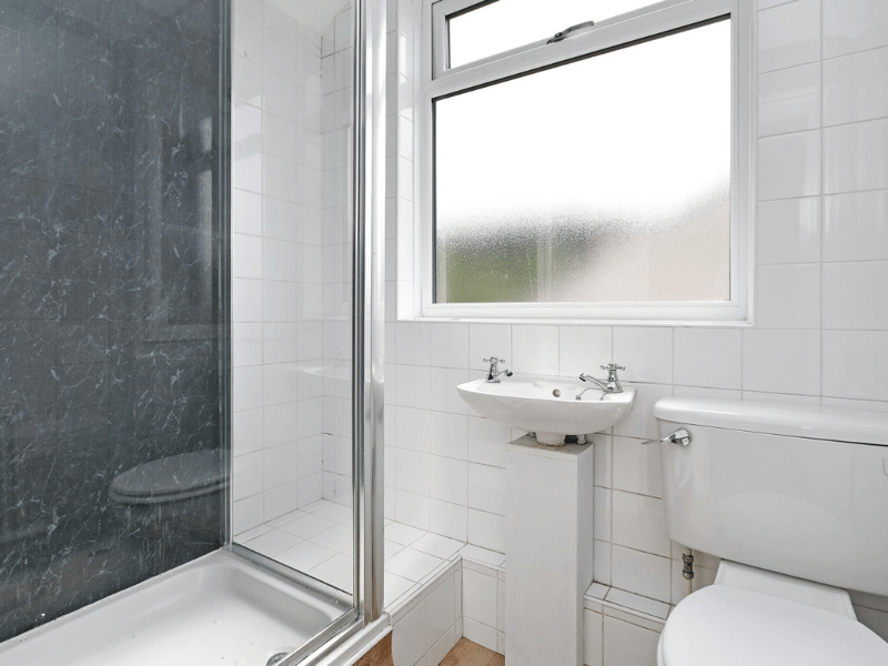 This smaller bathroom also has privacy windows, and raised shower, and storage space. 