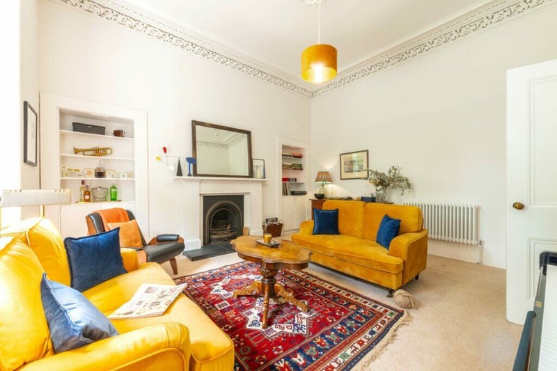 Inside the stylish yet traditional bay windowed sitting room with feature open fire and beautiful cornicework. 