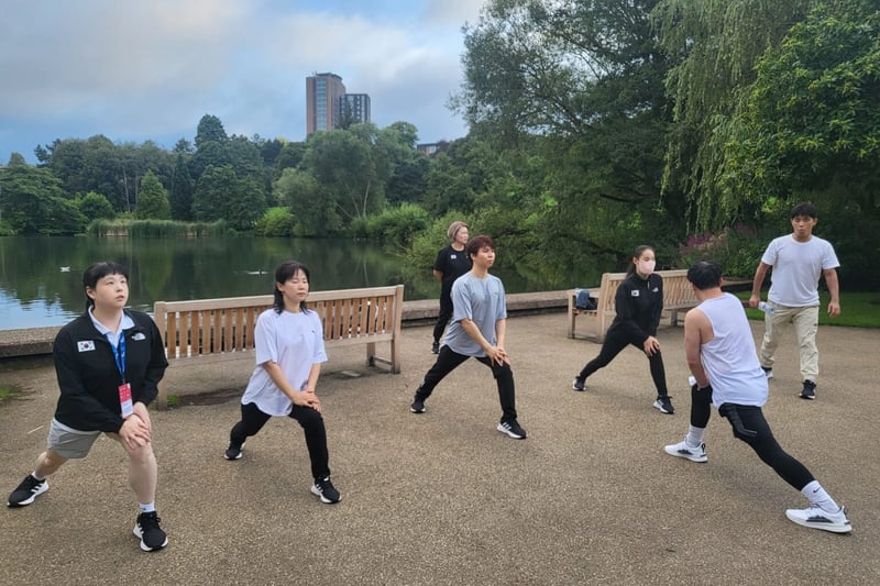 South Korean Showdown national team in a training session next to the lake of the University of Birmingham, with the Chamberlain Tower rising from the trees in the horizon
