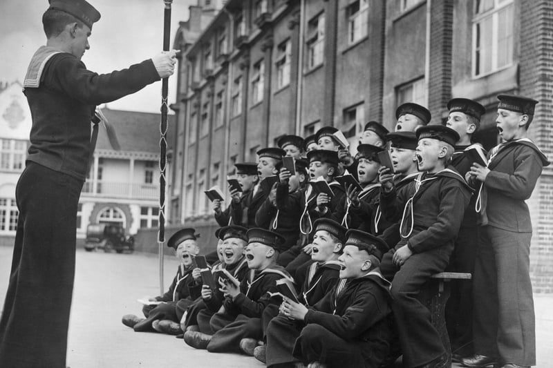 The boys of the Royal Nautical School, at Portishead in Bristol, follow the conductor at rehearsals for the school’s carol concert in 1934.