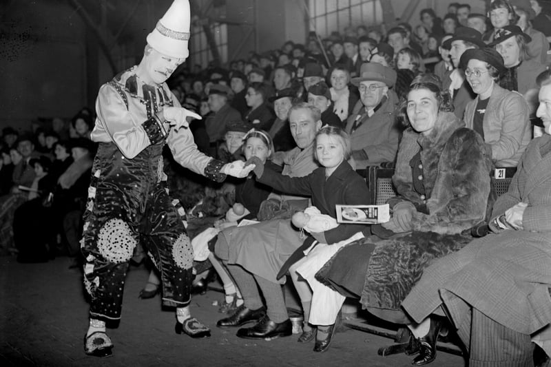 A clown entertaining a crowd  at a circus performance in 1940