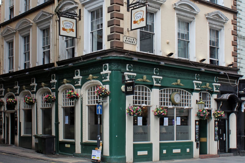Built in the 1850s, The Saddle Inn has notable elliptically arched windows, carved heads and rich friezes and cornices. Historic England awarded the building Grade II-listed status in 1985. A traditional pub serving cask ales, with a superb choice of Gins.