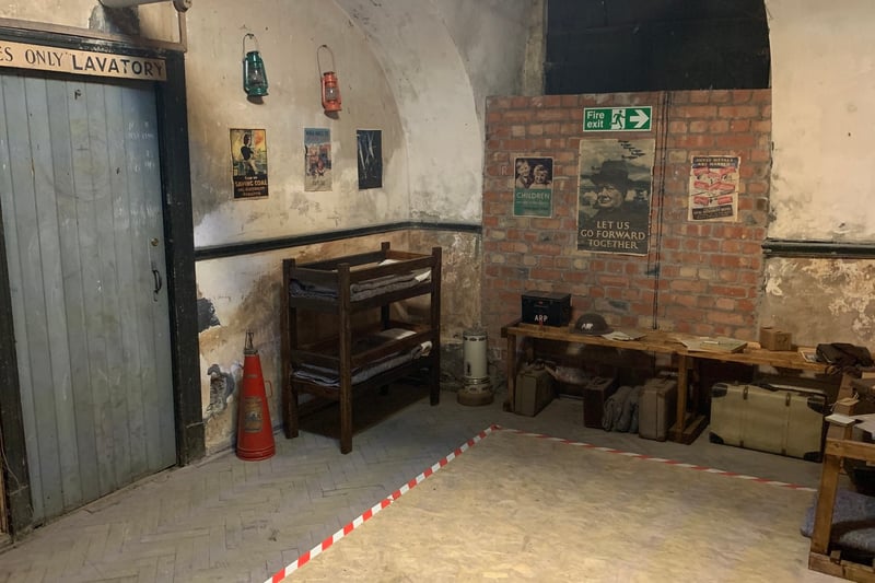 Original posters from the Second World War remain on the walls of the cloakroom heading to the ladies lavatory. The wall of the old Corn Exchange basement blends with the brickwork from the air raid shelter reinforcement. 