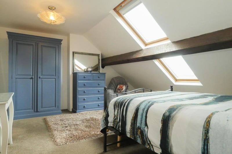 This bedroom on the second floor features exposed beams and Velux windows. 
