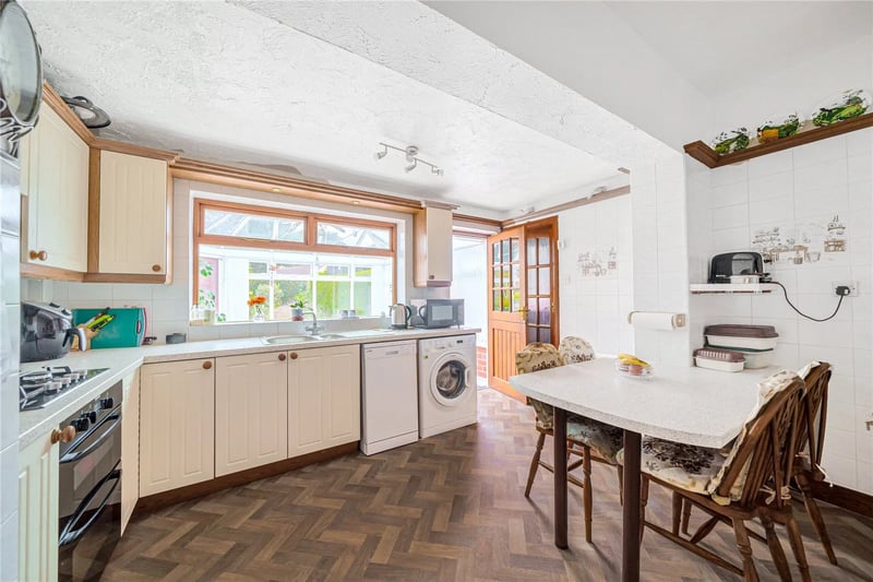 The kitchen with doors to the rear garden is fitted with cream units and a built-in double oven.