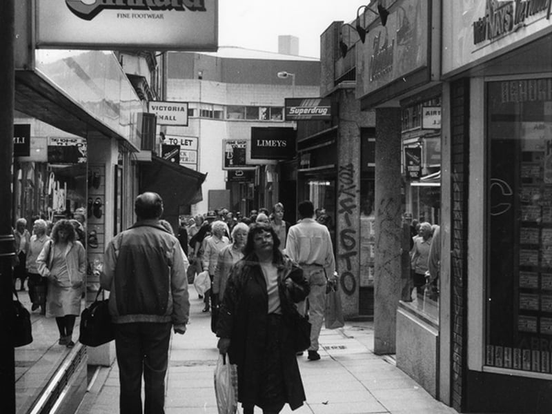 Shoppers on Chapel Walk, Sheffield, showing No. 37 Charles Clinkard shoe shop with the Crucible Theatre in the background, in 1994. Photo: Picture Sheffield