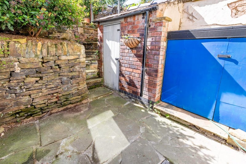 The rear of the property also features a small, enclosed courtyard with brick outhouse for storage.
