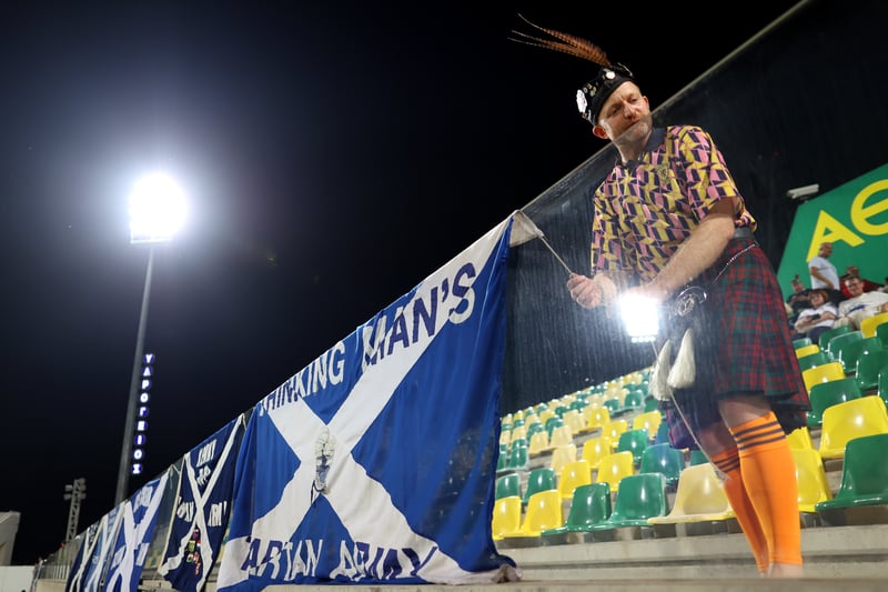 A fan of Scotland is seen with a flag inside the stadium.