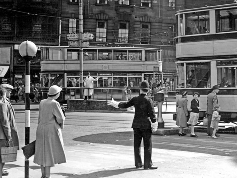 A police officer conducts traffic at Coles Corner, at the junction of Church Street and High Street, in Sheffield city centre in April 1952. Photo: Picture Sheffield/Press Photo Agency