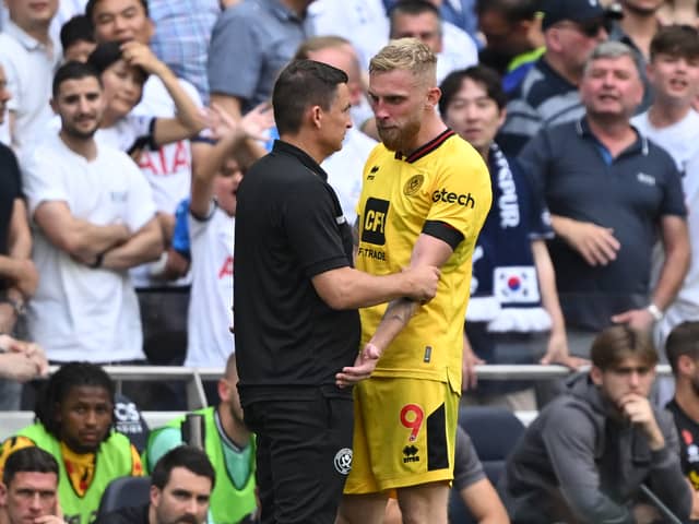 Oli McBurnie explains to Sheffield United boss Paul Heckingbottom why he was sent off against Tottenham (Photo by JUSTIN TALLIS / AFP) 