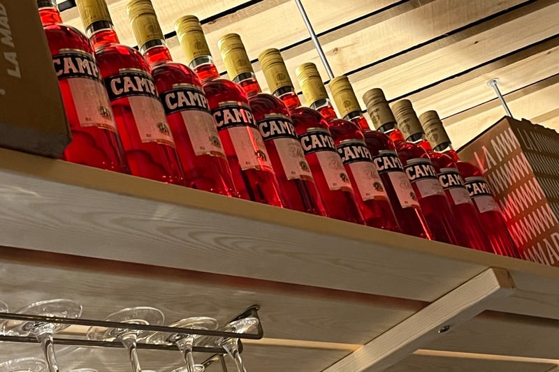 Above the bar, colourful bottles of Campari add to the Italian feel.