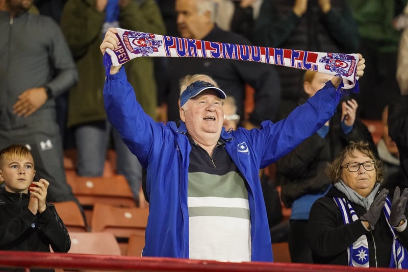 A Pompey fan holds his scarf aloft in support of his team. 