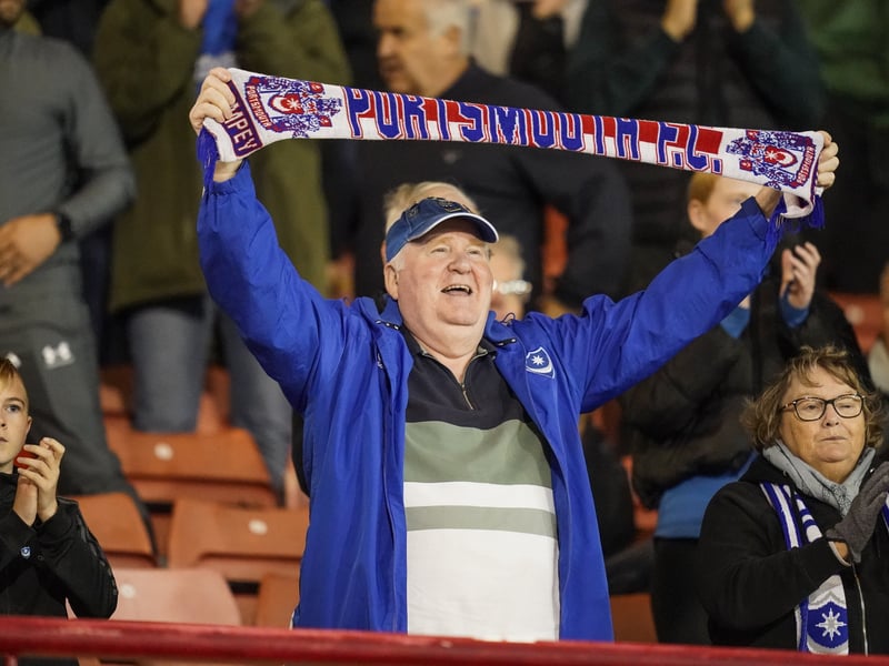 A Pompey fan holds his scarf aloft in support of his team. 