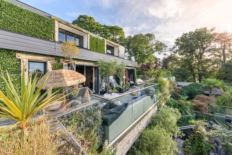 The balcony overlooks a luscious space littered with plants and tree's
