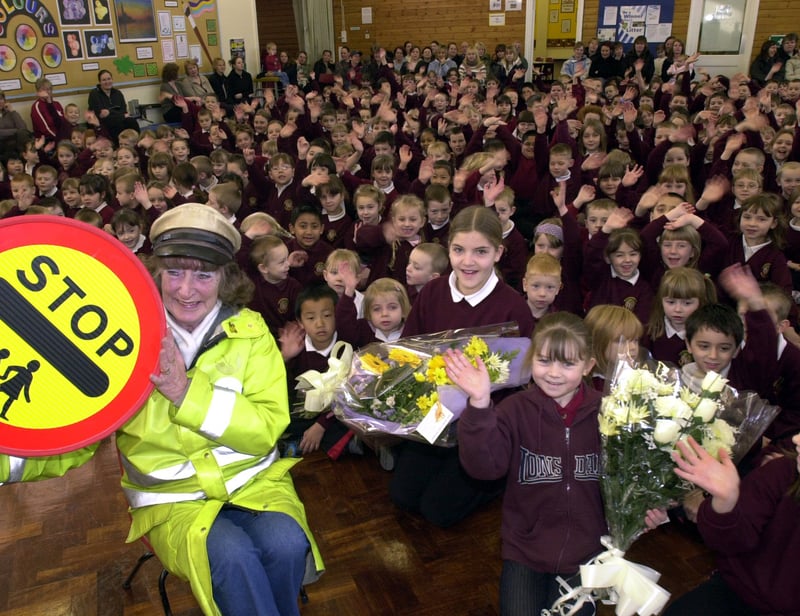 Lollipop lady Val Hutchinson pictured with pupils at Woodhouse West Primary School in February 2004