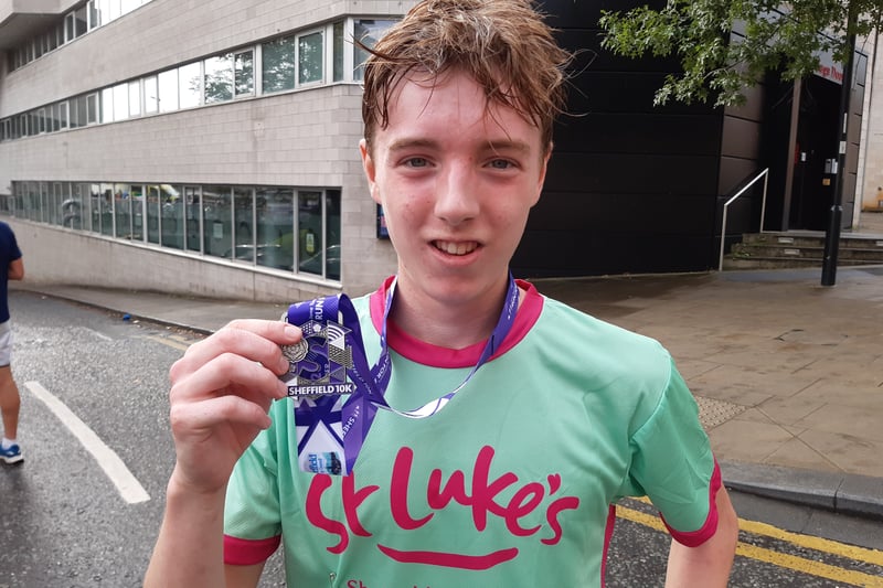 One of the runners shows his medal after completing the Sheffield 10k. Picture: David Kessen, National World