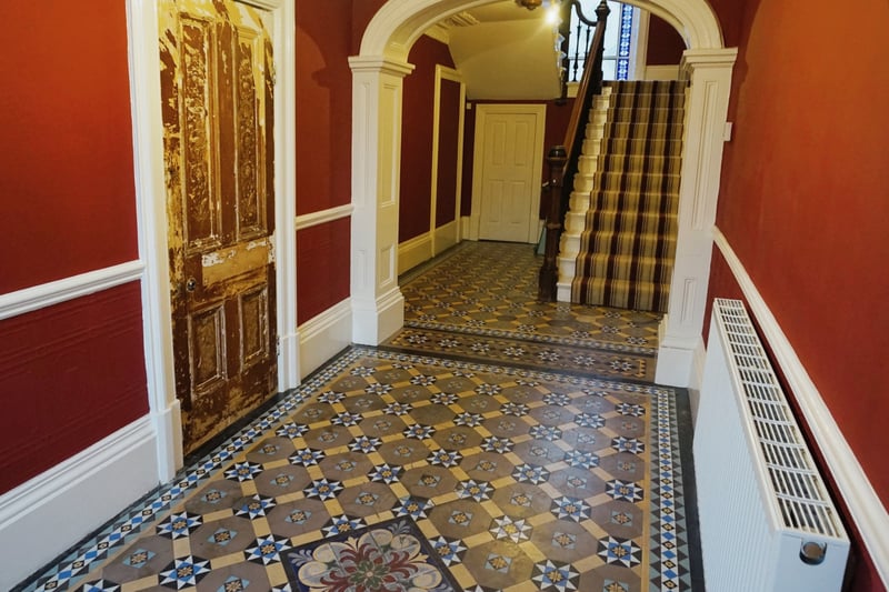 The entrance hall with original tiled flooring and stained glass windows.