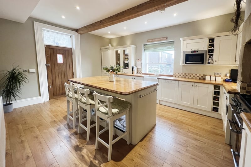 The kitchen is fitted with a range of matching wall and base units with solid wood work surfaces over.