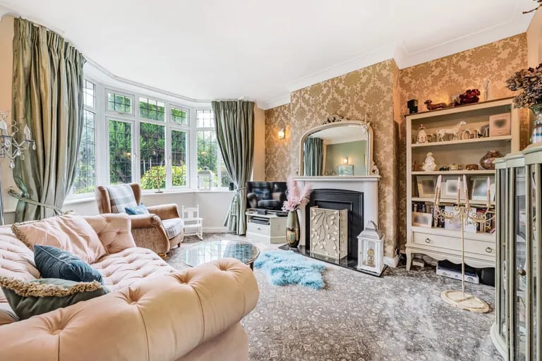 To the front is this charming living room with a large bay window.
