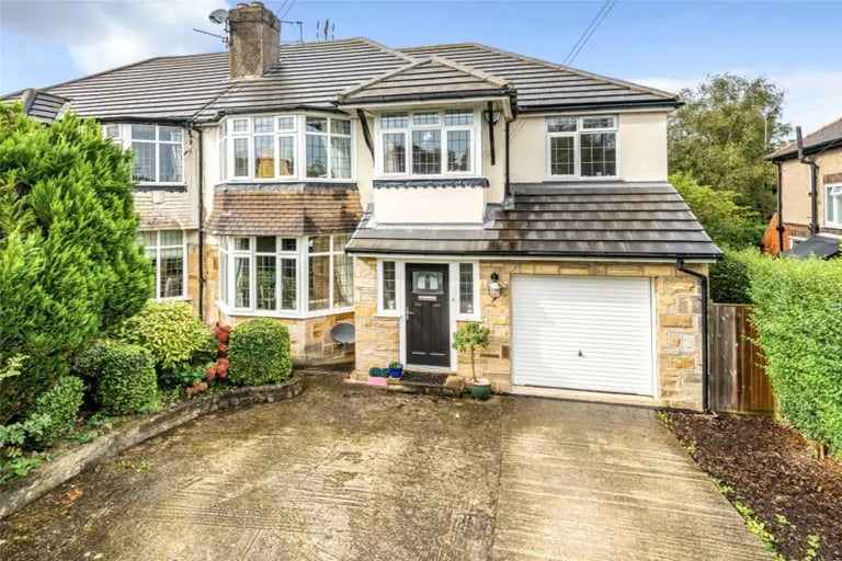 This extended family home in Moortown has a large driveway and garage to the front.