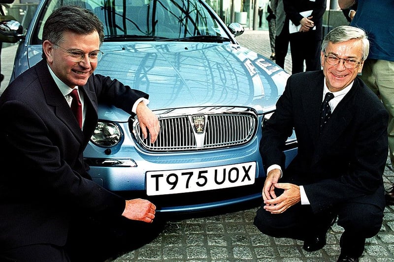LONDON, UNITED KINGDOM - JUNE 23:  BMW's Chairman Joachim Milberg (R) with Secretary for Trade and Industury Stephen Byers pose for photographers in front of a Rovers new 75 model car after the two announced in London, 23 June 1999 a package of support for Rover's Longbridge car plant in Birmingham.  BMW is to receive 152 million British pounds (240 million USD) in aid from the British government for its troubled Rover unit.  (Photo credit should read MIKE SIMMONDS/AFP via Getty Images)
