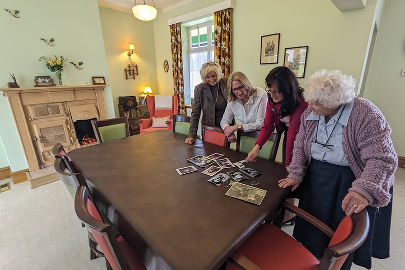 Volunteers and staff looking back at photographs from the past. 