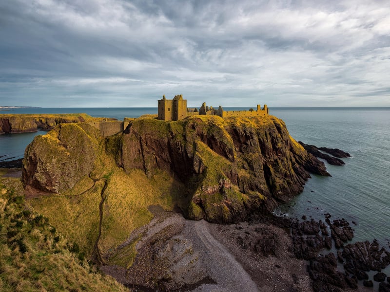 You can find Dunnottar Castle along the Aberdeenshire Coastal Trail on a rocky outcrop, around twenty miles from Aberdeen itself. Some believe that the site was originally inhabited by the Picts who may have done so as far back as 5000 BC. The name “Dunnottar” is derived from the Gaelic “Dùn Fhoithear” which means “fort on the shelving slope”.