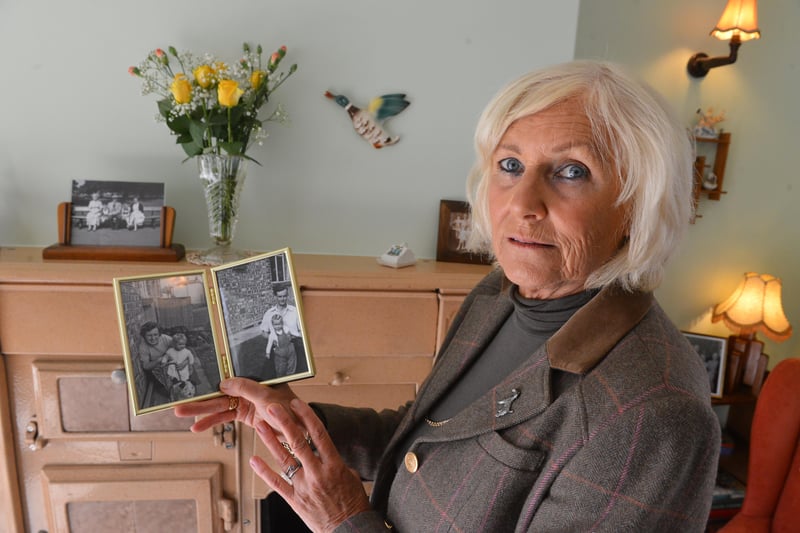 Christine Tindle, 68, with a photograph of her as a child with her parents.