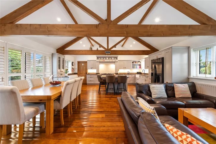The absolutely stunning family room and kitchen with exposed wooden beams.