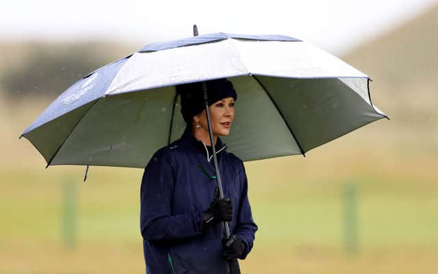 Actress Catherine Zeta-Jones shelters under an umbrella during the first round of the Dunhill Championship.